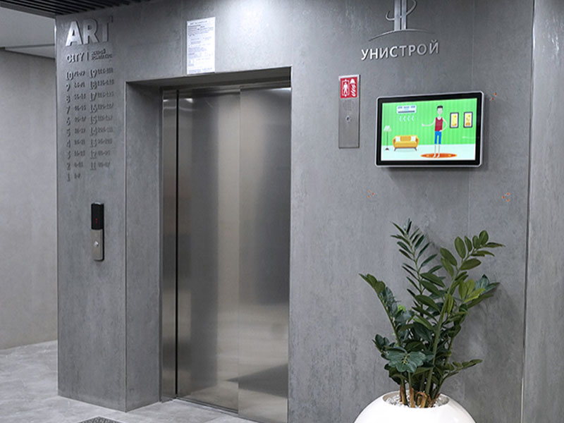 Монитор Videocomplex ADM221m с рекламой у лифта в подъезде жилого комплекса